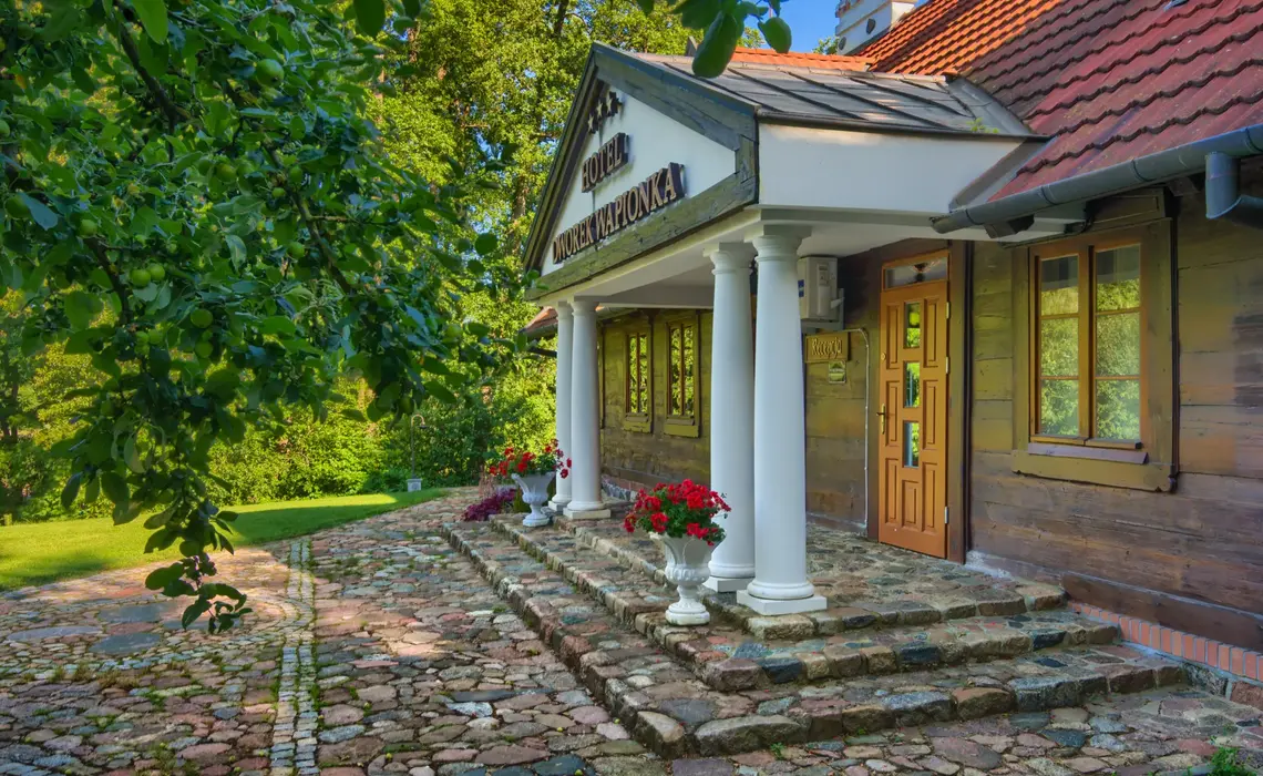 Historická budova Hotela Dworek Wapionka obklopená zeleňou